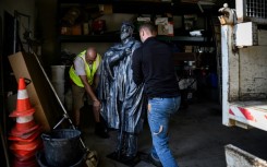 Abbe Pierre's statue is being stored alongside gardening equipment in a village workshop