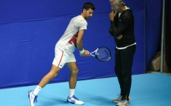 Italian fitness coach Marco Panichi (R) working with Serbia's Novak Djokovic during the 2022 Tel Aviv Open