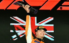McLaren's British driver Lando Norris (C) celebrates winning on the podium after the Formula One Singapore Grand Prix