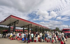 People wait in line for gasoline in the aftermath of Hurricane Helene on September 29, 2024 in Fletcher, North Carolina