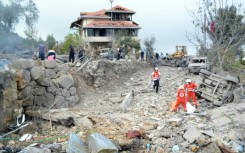 Red Cross paramedics unearth a body at the site of an Israeli air strike that targeted the northern Lebanese village of Aito