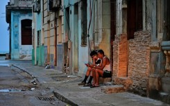 People check their phones in Havana on October 19, 2024