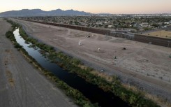 Vehicles guard the US side of the border with Mexico