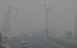 Commuters drive along a road amid heavy smog in Lahore