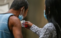A man spits a sputum sample during a tuberculosis screening at a health centre in Valenzuela in the Philippines