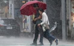 People walk along a street in heavy rain due to Super Typhoon Kong-rey in Keelung, Taiwan, on October 31