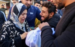 A woman cries over a two-year-old child killed in an Israeli strike in Gaza Thursday