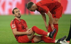 Bayern Munich forward Harry Kane (L) grabs his injured hamstring before being subbed off in Saturday's 1-1 draw with Borussia Dortmund