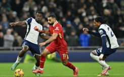 Liverpool star Mohamed Salah (C) bursts between  Yves Bissouma (L) and Djed Spence of Tottenham Hotspur during a  Premier League match in London on December 22, 2024.

