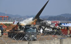Firefighters and rescue personnel work near the wreckage of the crashed Jeju Air Boeing 737-800 