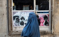 An Afghan woman stands at a window in Kabul on January 31, 2024