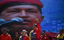 Nicolas Maduro was thrust into power as the handpicked successor of Hugo Chavez (on screen) who died of cancer in 2013 but is still hailed as a revolutionary hero by many