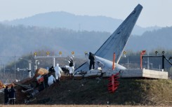 Officials investigate the site where a Jeju Air Boeing 737-800 aircraft crashed and burst into flames at Muan airport