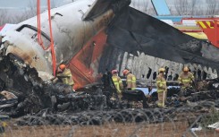 Firefighters and recovery teams work at the scene where a Jeju Air Boeing 737-800 series aircraft crashed and burst into flames at Muan International Airport