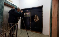 A photographer shoots the closed door of Al Jazeera TV's office in the Israeli-occupied West Bank city of Ramallah following a suspension order from the Palestinian Authority