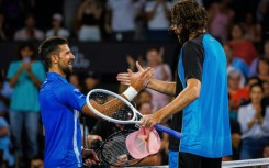 American Reilly Opelka (right) shakes hands with  Serbia's Novak Djokovic after beating him in the quarter finals of the Brisbane International