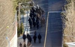 Anti-corruption investigators walk up a hill inside the presidential residence of impeached South Korea President Yoon Suk Yeol in Seoul on Friday