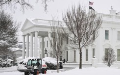 Workers remove snow outside the White House in Washington