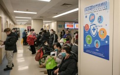 People wearing masks wait in the respiratory department of a Beijing hospital this week