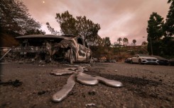 Molten metal flows from a car burnt out by the Palisades Fire in Los Angeles, California 