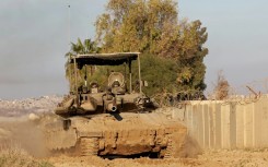 An Israeli tank drives into position near Israel's southern border with the Gaza Strip on January 14, 2025