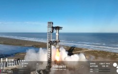 In this screen grab taken from the SpaceX broadcast the Starship's Super Heavy Booster is grappled mid-air as it returns to the launch pad at Starbase near Boca Chica, Texas, on January 16, 2025