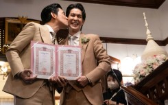 Thai actors Apiwat 'Porsch' Apiwatsayree (L) and Sappanyoo 'Arm' Panatkool pose after registering their same-sex marriage Thursday