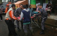 A survivor is brought to an Indonesian hospital from the site of a landslide triggered by heavy rain