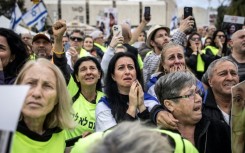 Relatives and friends of Israeli hostages watch the release of four women soldiers from captivity in Gaza, on a screen at 'Hostage Square' in Tel Aviv