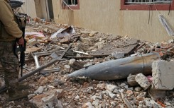 A Lebanese soldier in Naqura, south Lebanon, checks the remains of a rocket in a residential area devastated by the war between Israel and Hezbollah