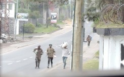 Armed men walking in the streets of Goma, some carrying their belongings
