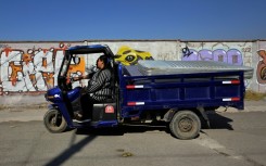 Marco Antonio Terron and his daughter Maria del Mar ride their three-wheeled scrap collection vehicle near Mexico City