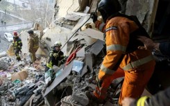 Ukrainian rescuers clearing rubble from a residential building following the overnight drone attack
