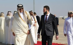 Qatar's Emir Sheikh Tamim bin Hamad Al-Thani (L) is welcomed by Syria's interim president Ahmed al-Sharaa in Damascus