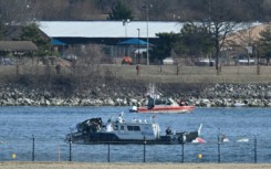 A police boat gathers wreckage along the Potomac River after American Airlines flight 5342 collided with a US Army helicopter