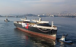 The Neoliner Origin, with its massive masts as yet unfurled 