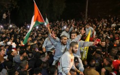 A crowd welcomes Palestinians formerly jailed by Israel as they arrive in a Red Cross convoy to Ramallah in the occupied West Bank