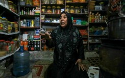 Shelves of foodstuffs line the walls of a shop in the Atme camp
