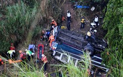 Firefighters and police work at the scene of a bus crash in Guatemala City on February 10, 2025