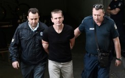 Russian Alexander Vinnik (C) is escorted by police officers as he arrives at a courthouse in Thessaloniki, Greece in 2017