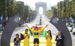 Geraint Thomas holds the Welsh flag aloft after his 2018 Tour de France triumph