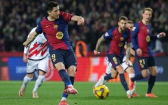 Robert Lewandowski converts the penalty that gave Barcelona victory over Rayo Vallecano and top spot in La Liga