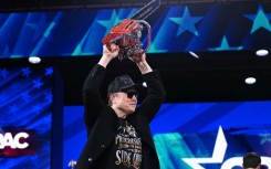 Elon Musk holds a chainsaw reading "Long live freedom, damn it" during the annual Conservative Political Action Conference (CPAC), a gift from Argentina's Javier Milei