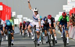 Tim Merlier raises his fist to celebrate a stage victory after two near misses in  the UAE Tour