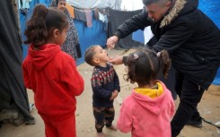 A Palestinian child at a camp for displaced people in Nuseirat, central Gaza, receives a polio vaccine in the third mass polio vaccination campaign for the territory