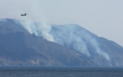 A helicopter is pictured above the wildfire near Ofunato