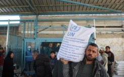 A Palestinian receives food aid from a United Nations distribution centre in Nuseirat refugee camp, central Gaza, after Israel announced a block on aid flows into the territory