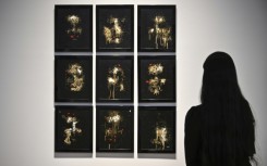 A person looks at AI artwork created by Pindar Van Arman's Emerging Faces at a preview for 'Augmented Intelligence' at Christie's on February 20, 2025 in New York City
