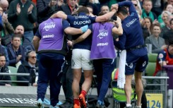 France's scrum-half Antoine Dupont (C) is helped from the field in Dublin