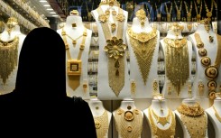 A woman examines gold jewellery at a shop in Dubai